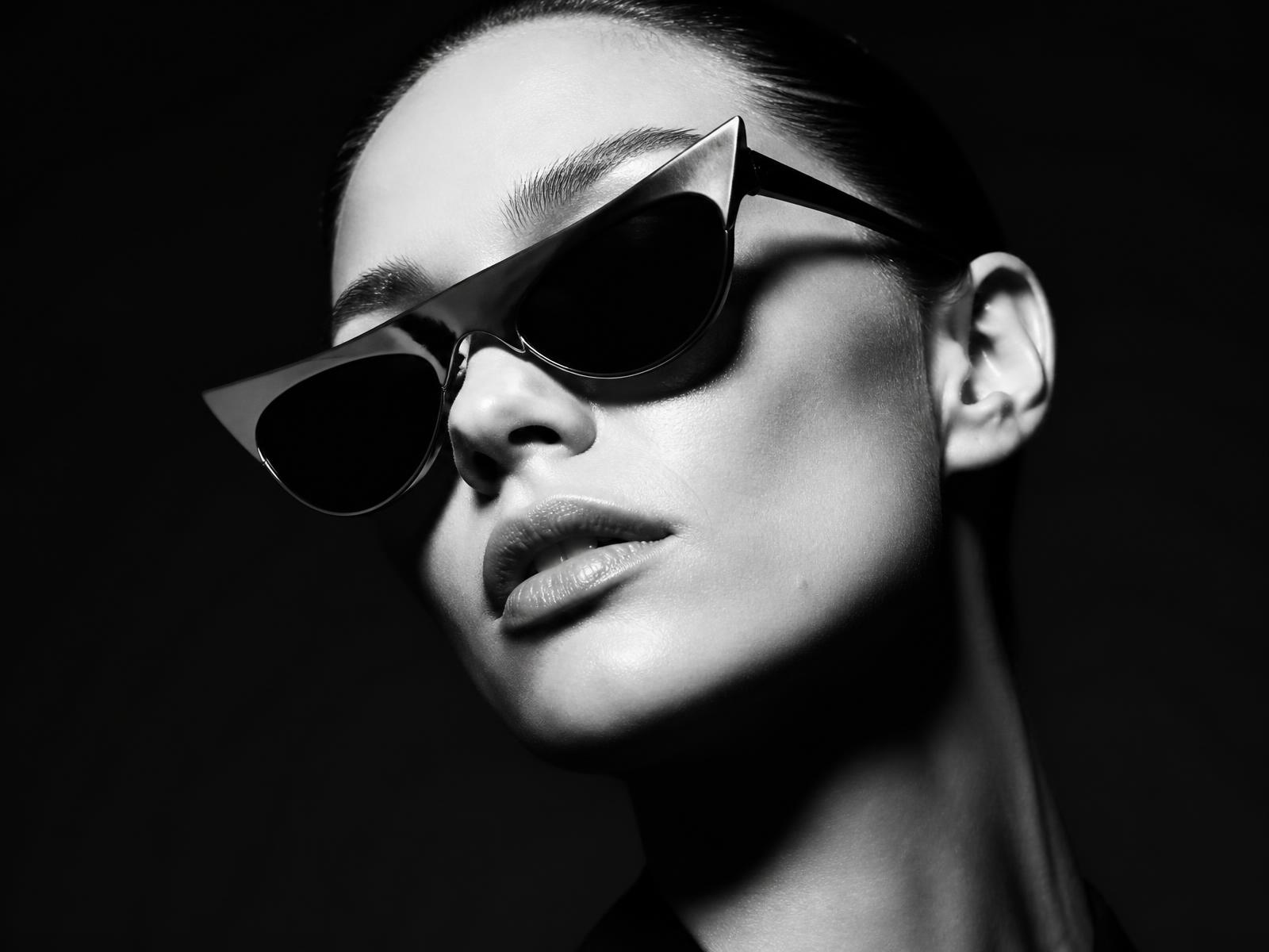 Dramatic monochrome portrait of a model wearing sculptural INAX sunglasses